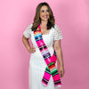 Woman wearing hot pink serape sash.