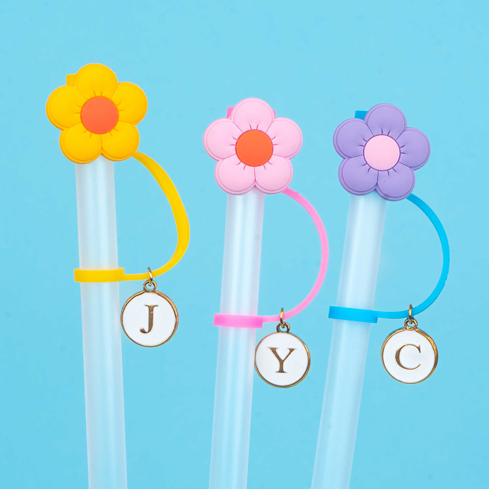 Close up of flower straw toppers and initial charms.
