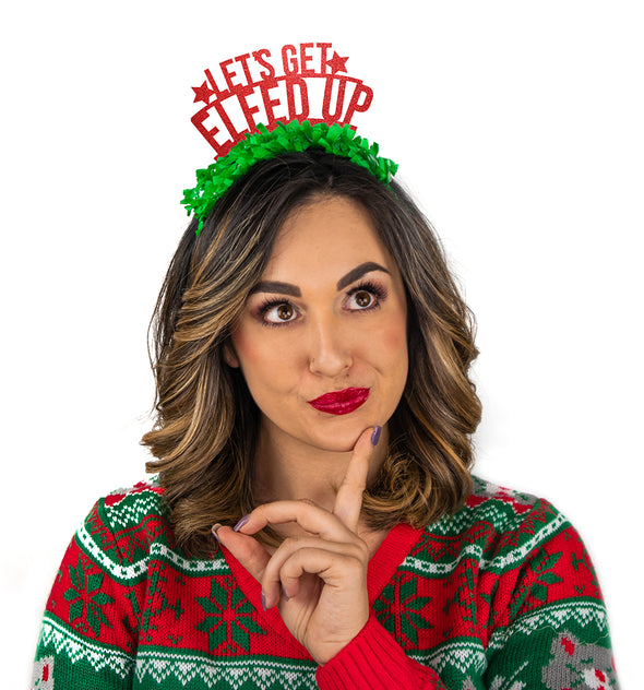 Red glitter party crown with green fringe saying "Let's Get Elfed Up" and has two small stars