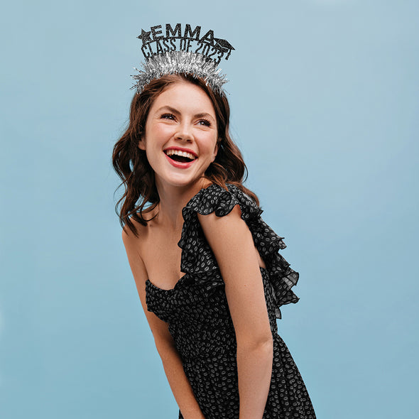 A girl wearing a custom graduation crown in silver and black