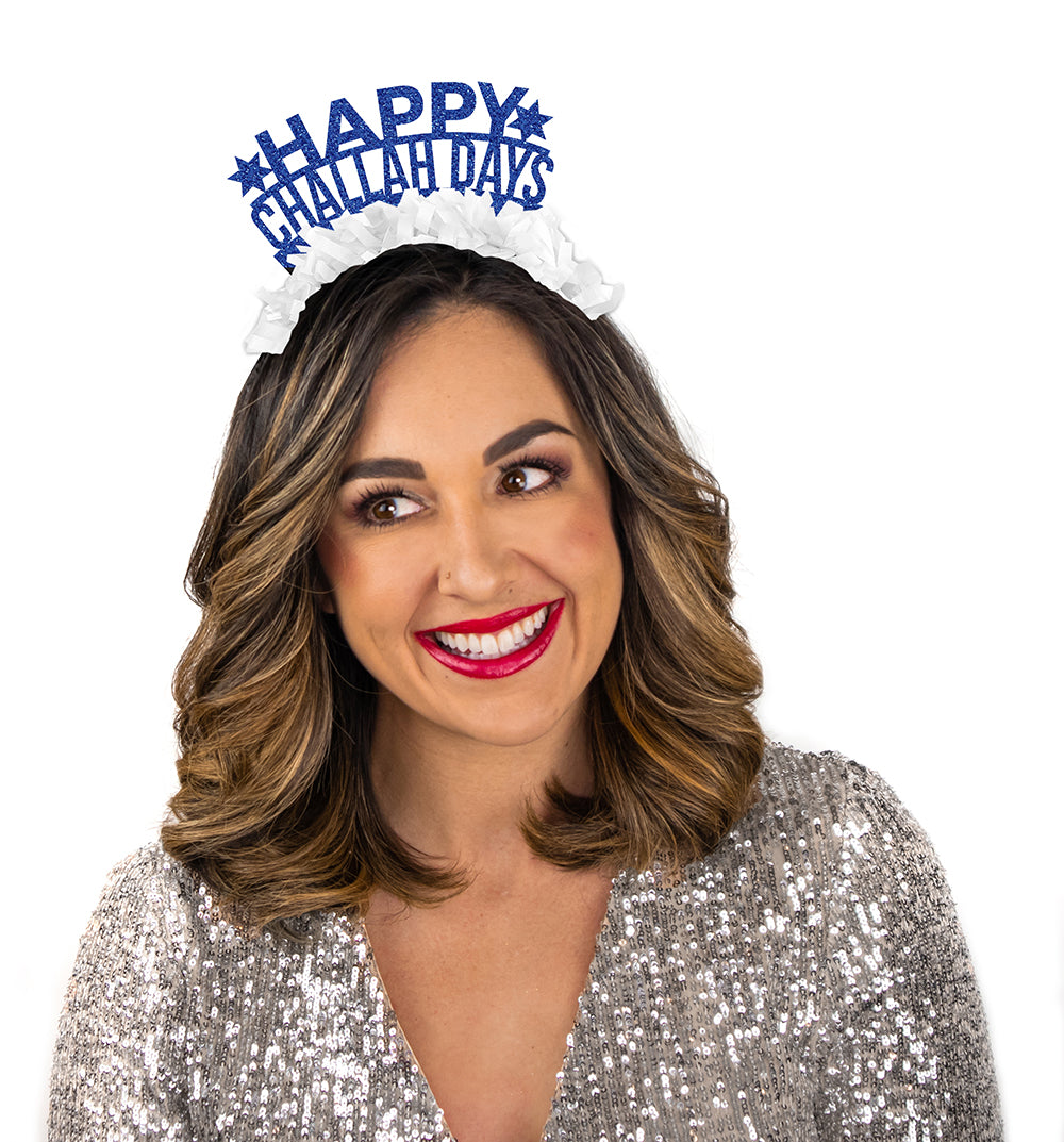 Young girl wearing party crown in blue and white saying Happy Challah Days.