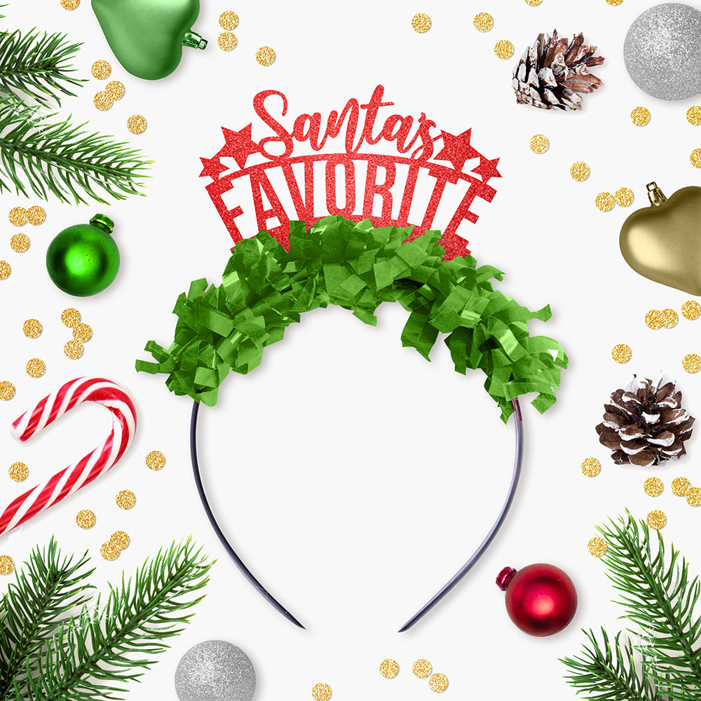 Red glitter and green fringe party crown that says "Santa's Favorite" "Santa's" is in cursive surrounded by Christmas Decor