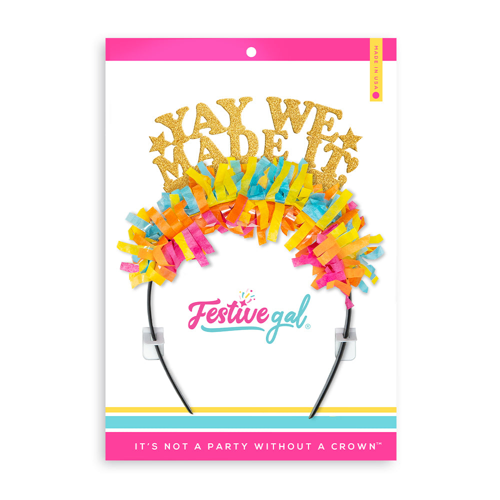 Graduation crown that says "Yay We Made It" in gold and multi inside a Festive Gal packaging